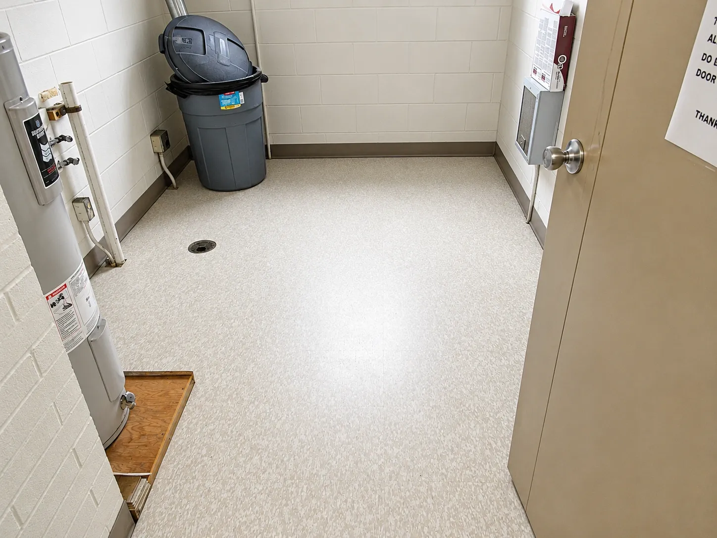 Painted utility room with white block walls and a tan door