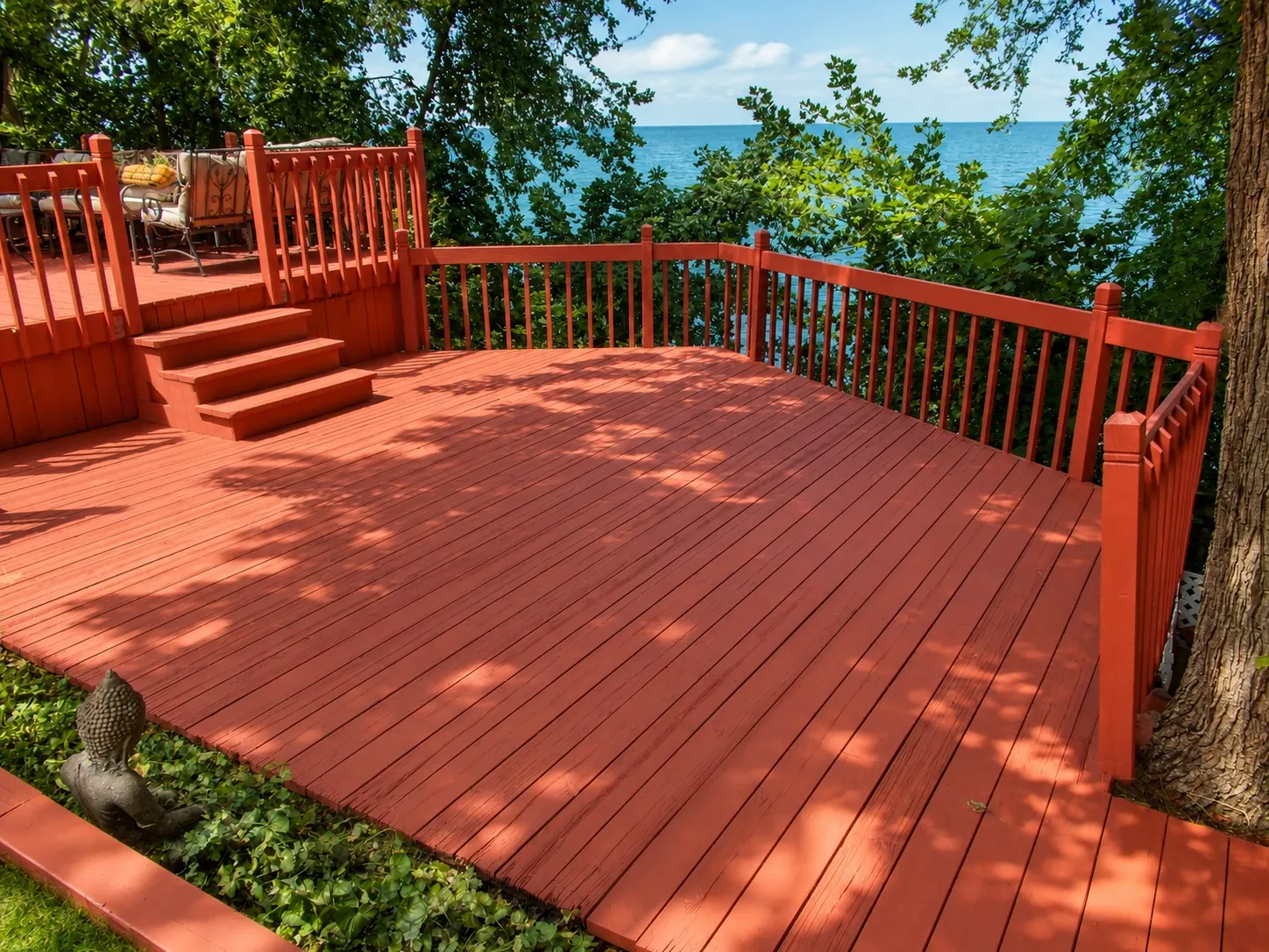 Elevated residential deck and railing with a red-brown finish