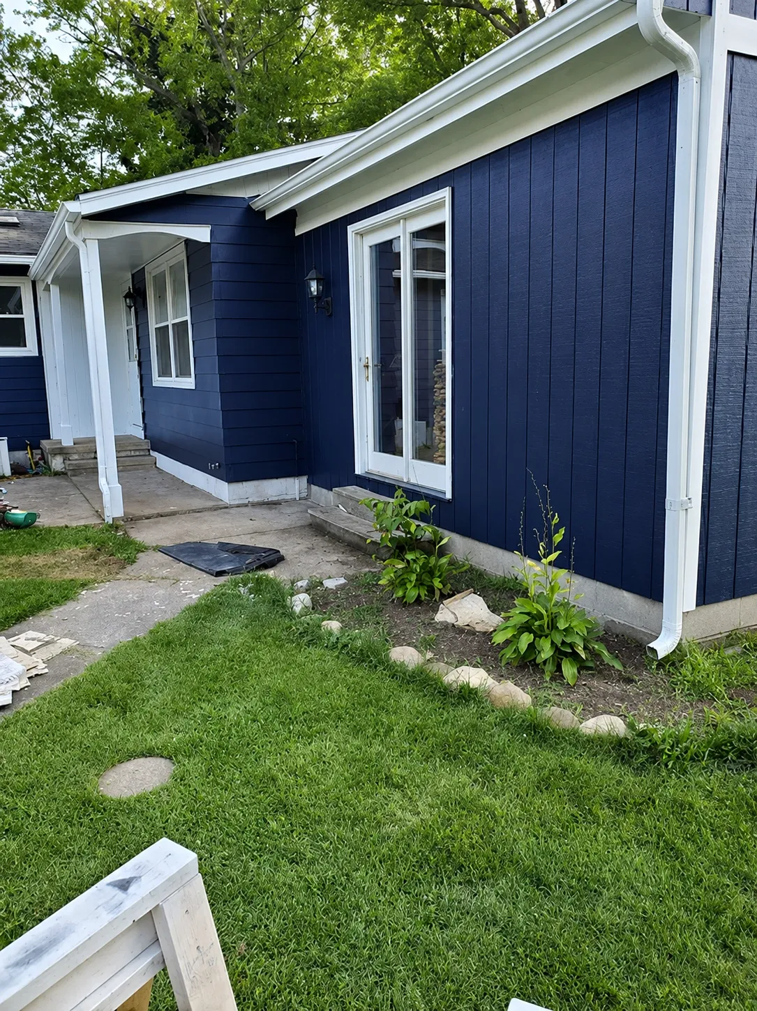Blue residential exterior with white window and roof trim