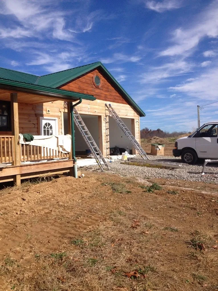 Exterior preparation work with ladders on a wood-sided building
