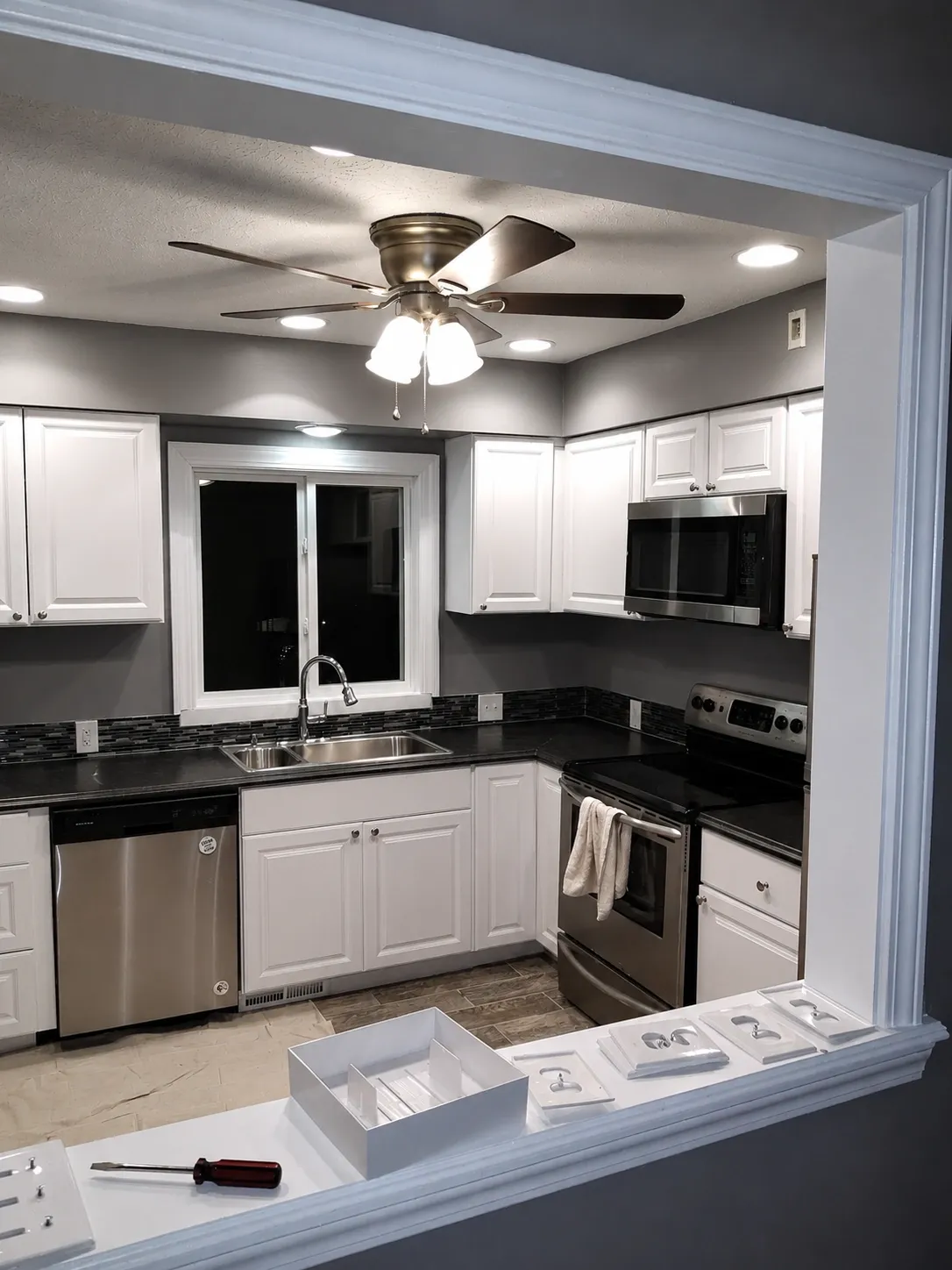 Bright kitchen interior with white cabinetry, walls, and trim