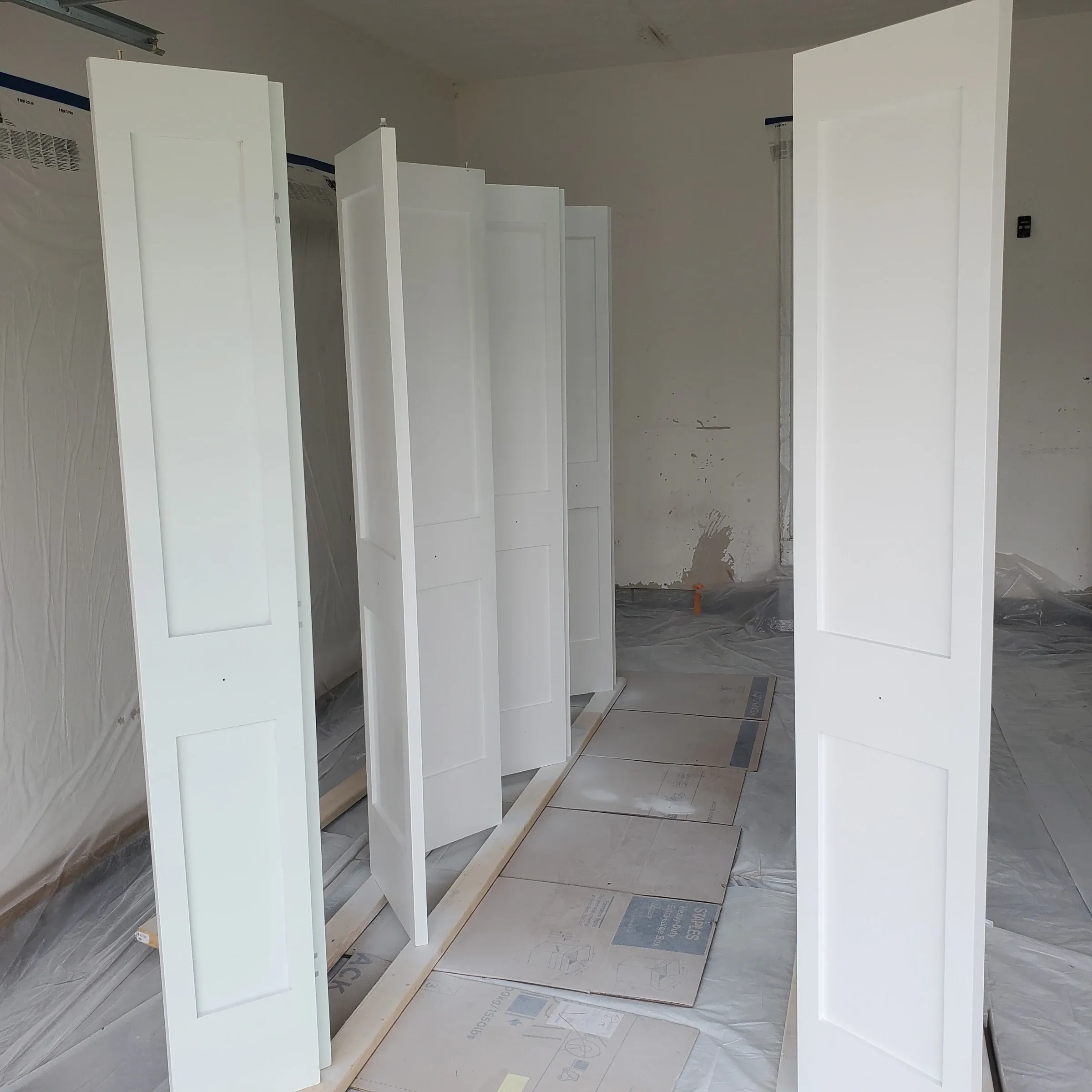 Interior hallway with floors and adjacent surfaces protected for painting