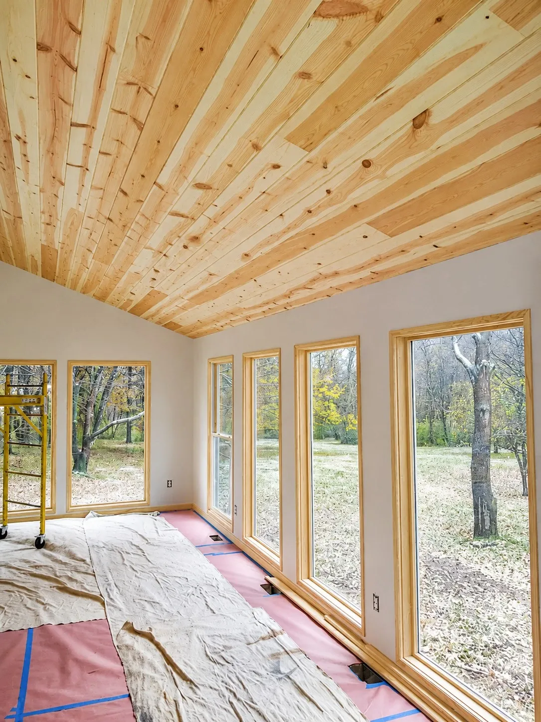 Interior room protected for painting with wall and trim work in progress